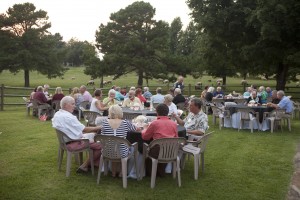Attendees enjoy the country setting complete with sheep in the background, at the home of Malcolm & Ellen Hayward.